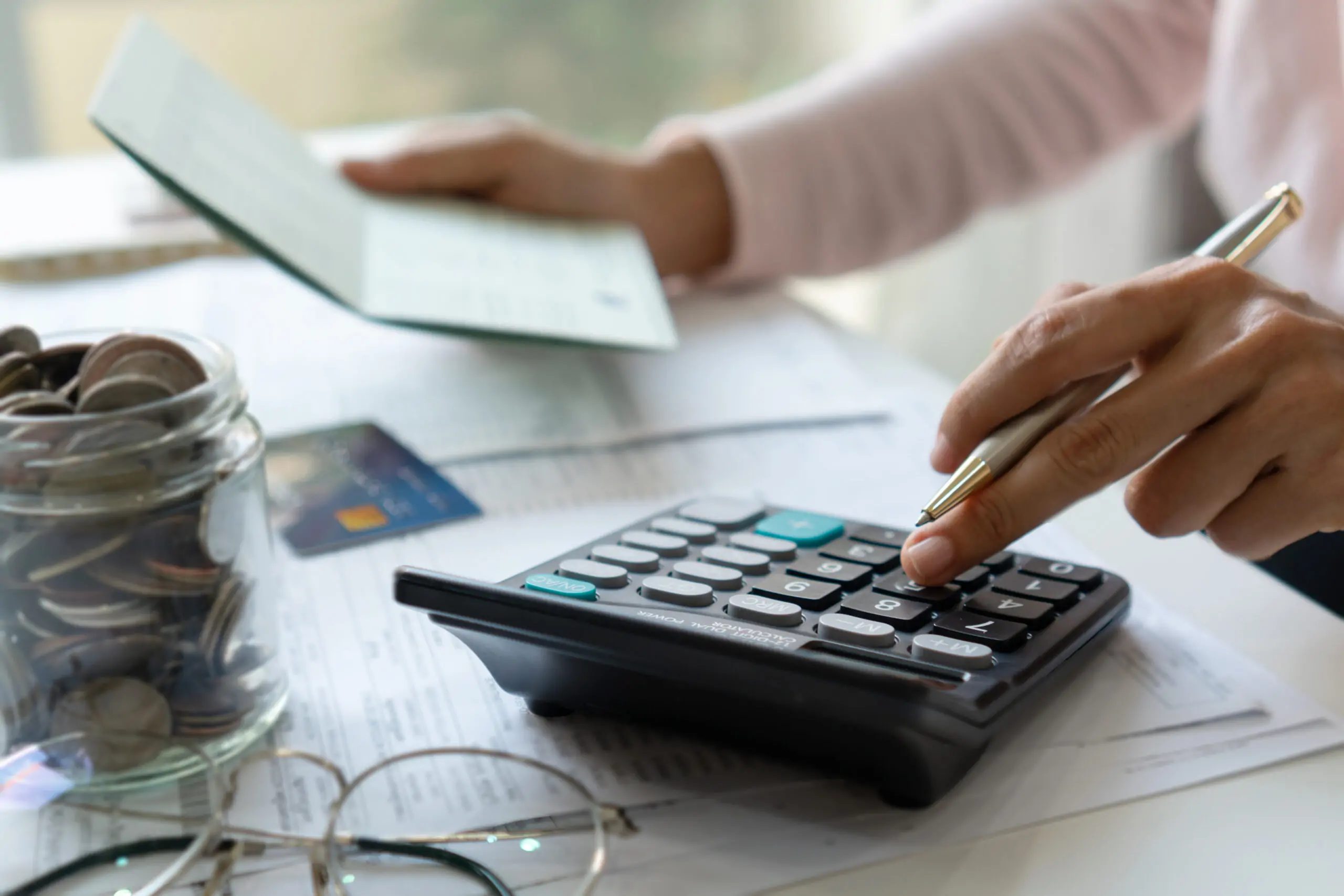 Person using a calculator to review costs associated with a $150k business loan